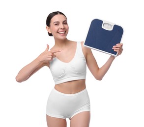 Diet and weight loss concept. Happy young woman with floor scale on white background