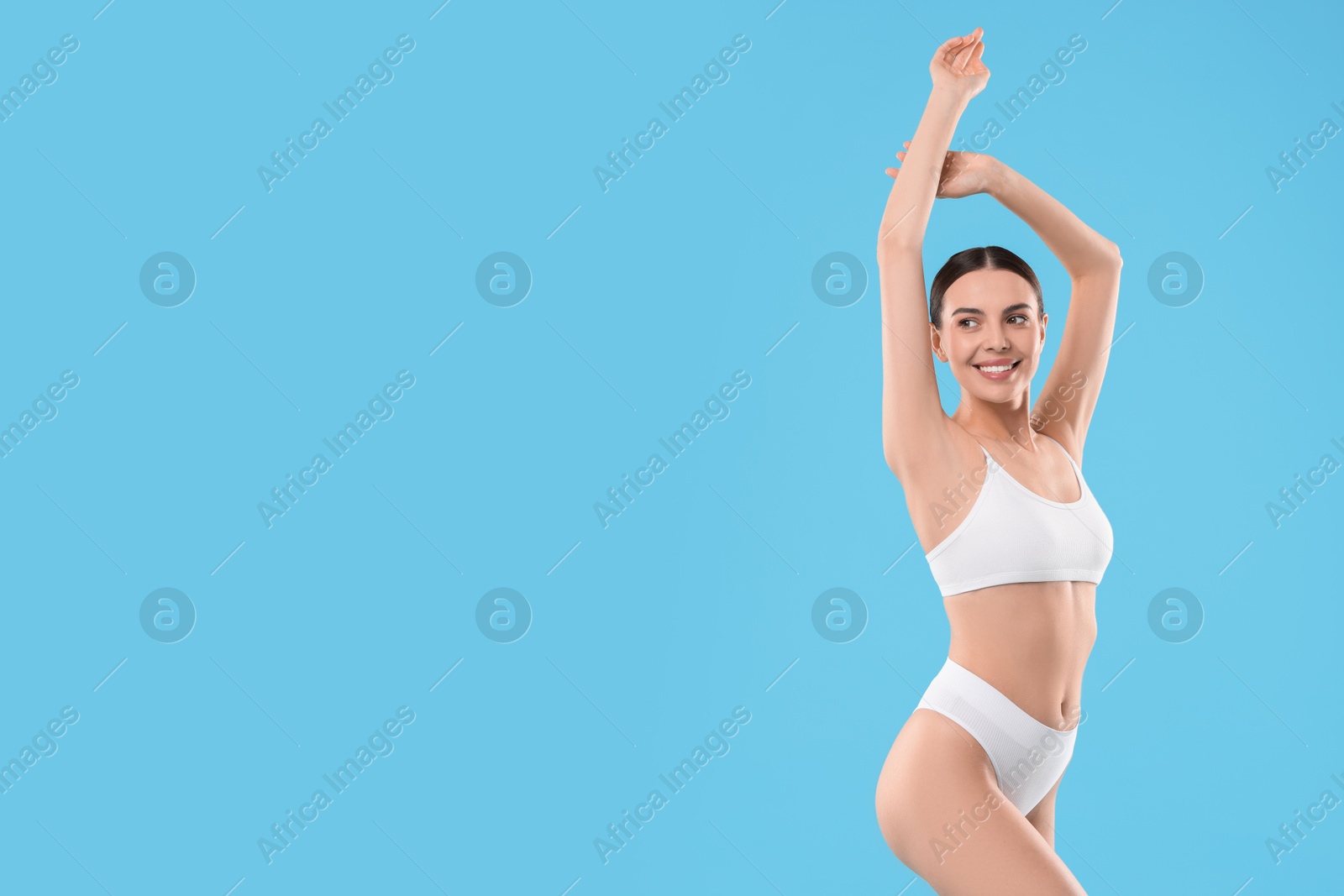 Photo of Diet and weight loss concept. Beautiful young woman with slim body against light blue background. Space for text