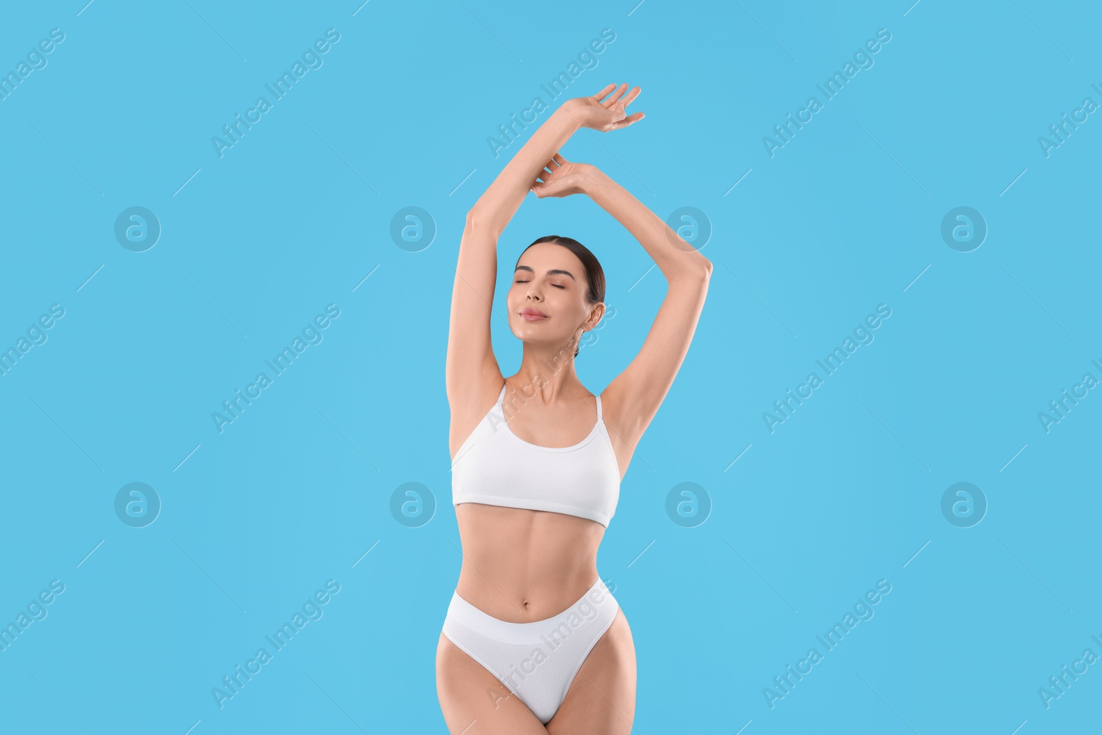 Photo of Diet and weight loss concept. Beautiful young woman with slim body against light blue background