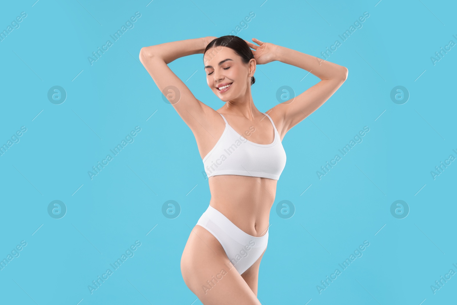 Photo of Diet and weight loss concept. Beautiful young woman with slim body against light blue background