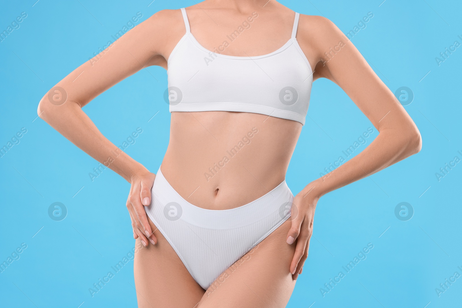 Photo of Diet and weight loss concept. Woman with slim body against light blue background, closeup