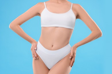 Diet and weight loss concept. Woman with slim body against light blue background, closeup