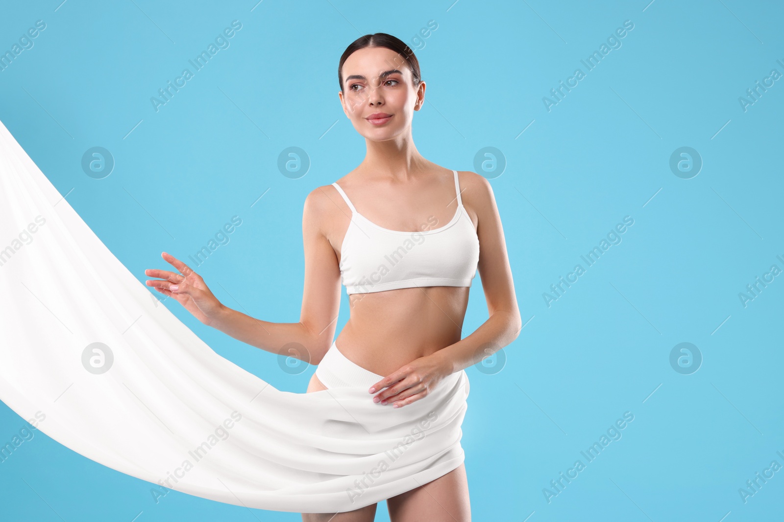 Photo of Diet and weight loss concept. Beautiful young woman with slim body on light blue background