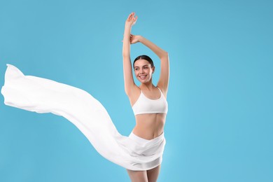 Diet and weight loss concept. Beautiful young woman with slim body on light blue background