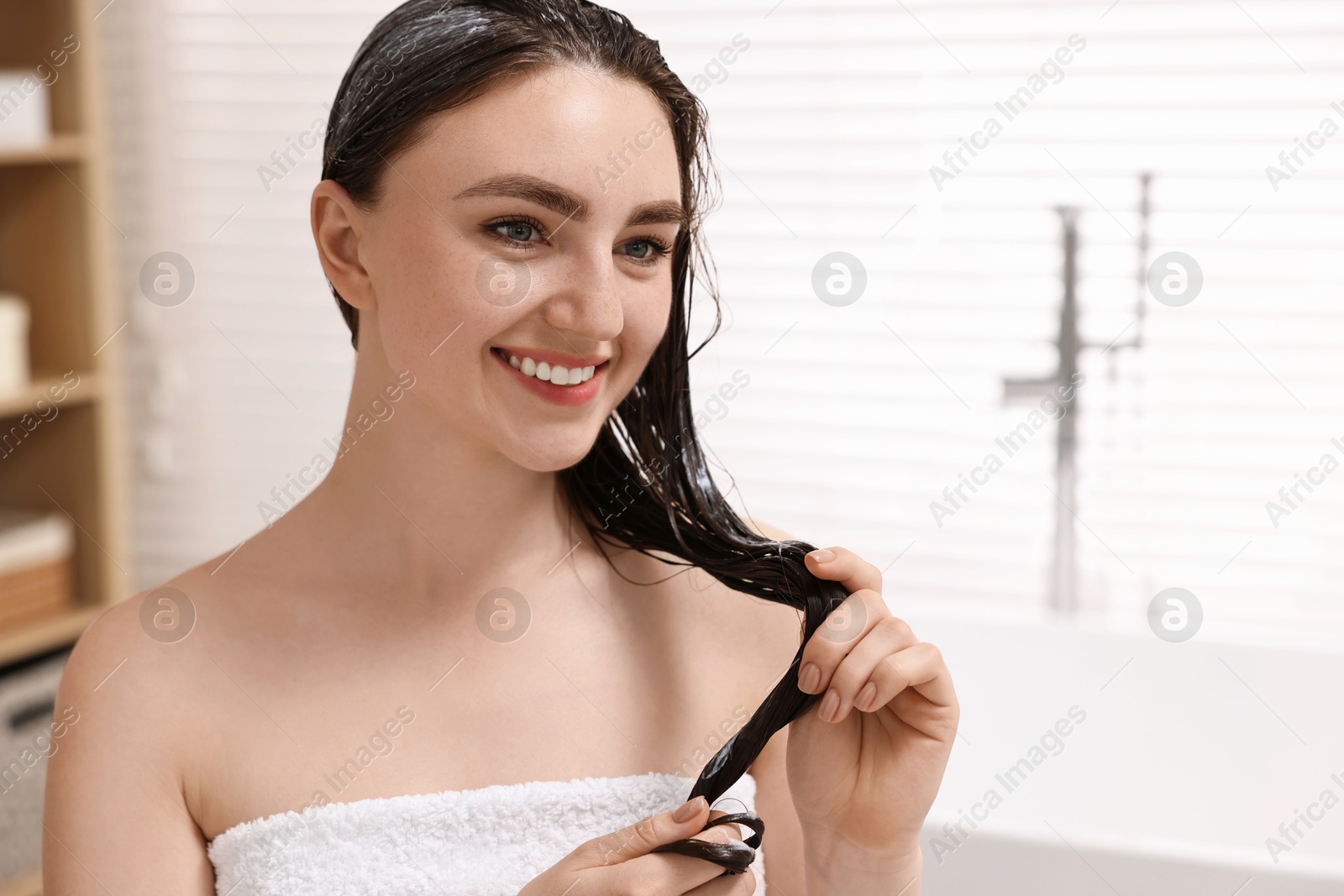 Photo of Smiling woman with applied hair mask in bathroom. Space for text