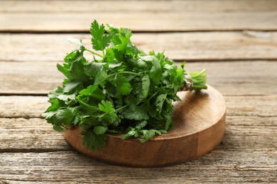 Photo of Bunch of fresh coriander on wooden table