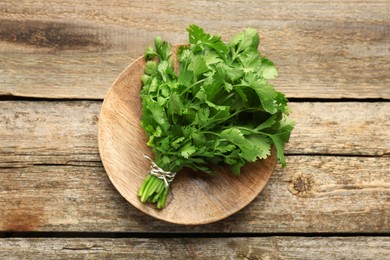 Bunch of fresh coriander on wooden table, top view