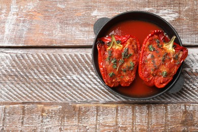 Photo of Tasty stuffed peppers in dish on table, top view. Space for text