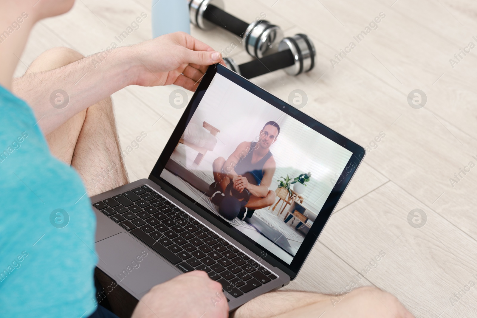 Photo of Online fitness trainer. Man watching tutorial on laptop indoors, closeup