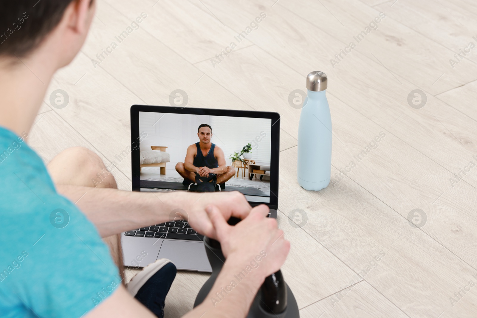 Photo of Online fitness trainer. Man watching tutorial on laptop indoors, closeup