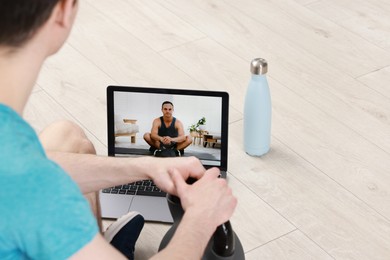 Online fitness trainer. Man watching tutorial on laptop indoors, closeup