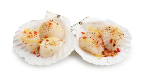 Raw scallops with lemon zest, spices and shell isolated on white