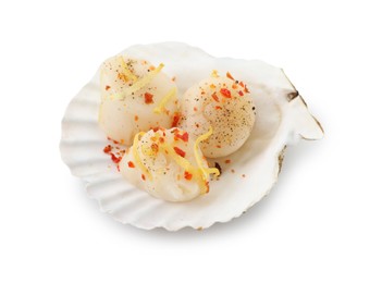 Raw scallop with lemon zest, spices and shell isolated on white