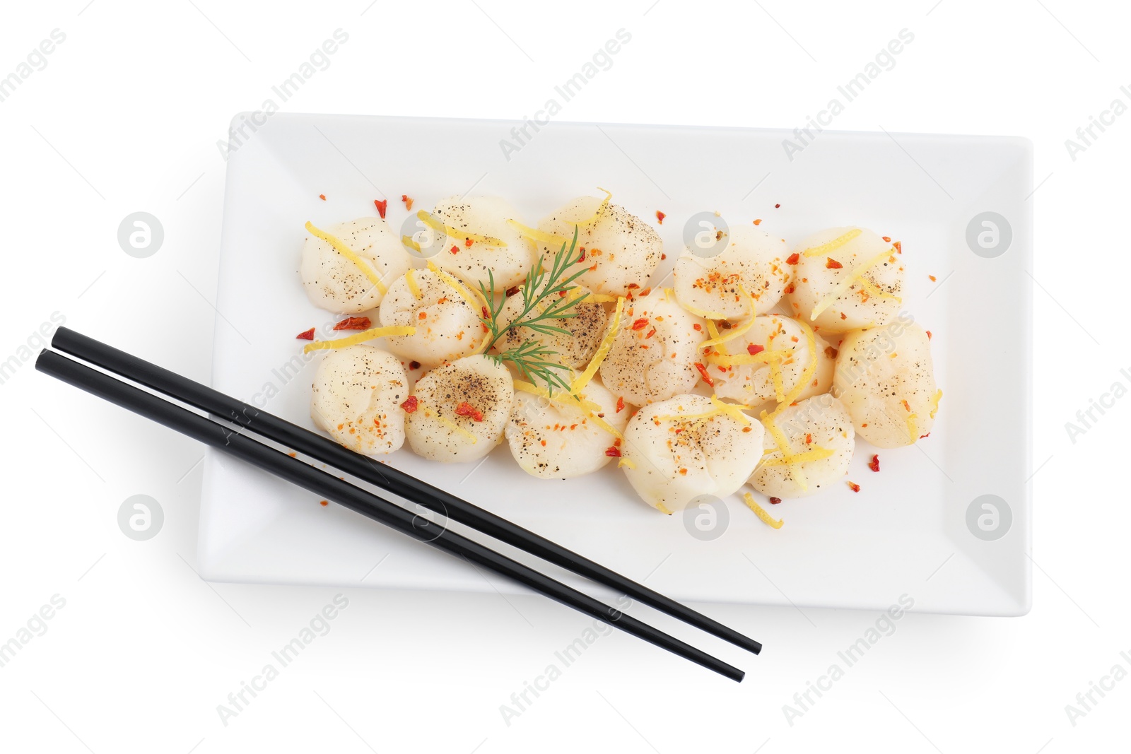 Photo of Raw scallops with spices, dill, lemon zest and chopsticks isolated on white, top view