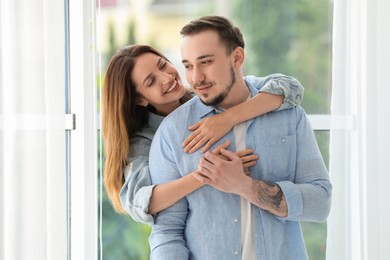 Photo of Happy woman hugging her boyfriend at home