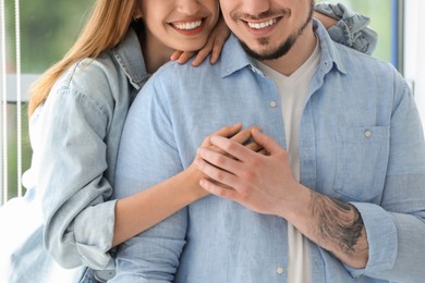 Happy couple holding hands at home, closeup