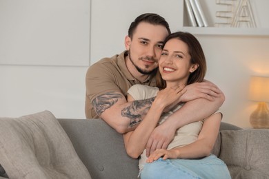 Man hugging his happy girlfriend at home