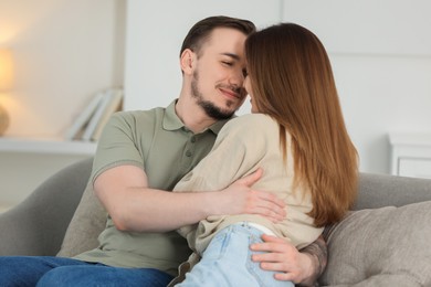 Cute couple hugging on sofa at home