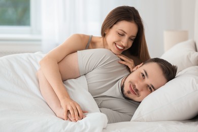 Photo of Happy couple enjoying each other in bed at home
