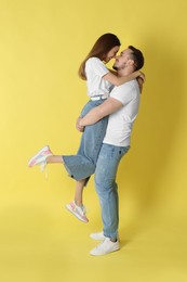 Photo of Happy couple hugging on yellow background. Strong relationship