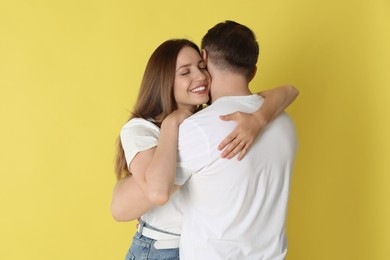 Photo of Happy couple hugging on yellow background. Strong relationship