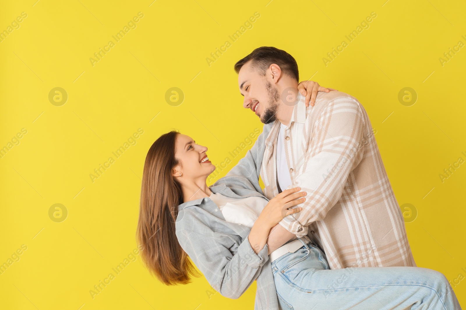 Photo of Happy couple dancing on yellow background. Space for text