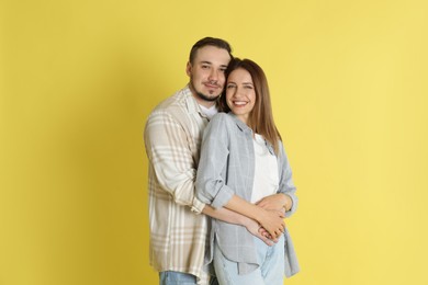 Photo of Happy couple hugging on yellow background. Strong relationship