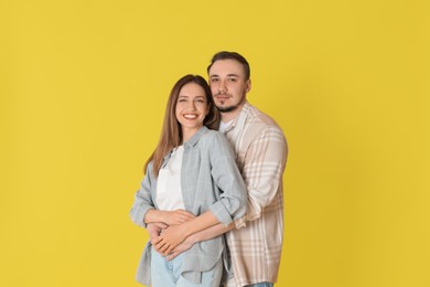 Photo of Happy couple hugging on yellow background. Strong relationship