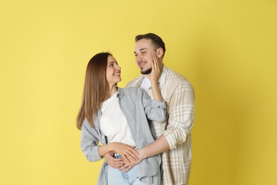 Photo of Happy couple hugging on yellow background. Strong relationship