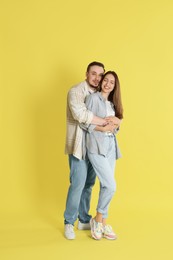 Photo of Happy couple hugging on yellow background. Strong relationship