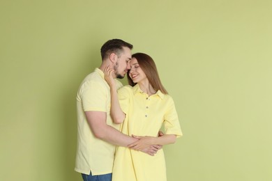 Photo of Cute couple hugging on green background. Space for text