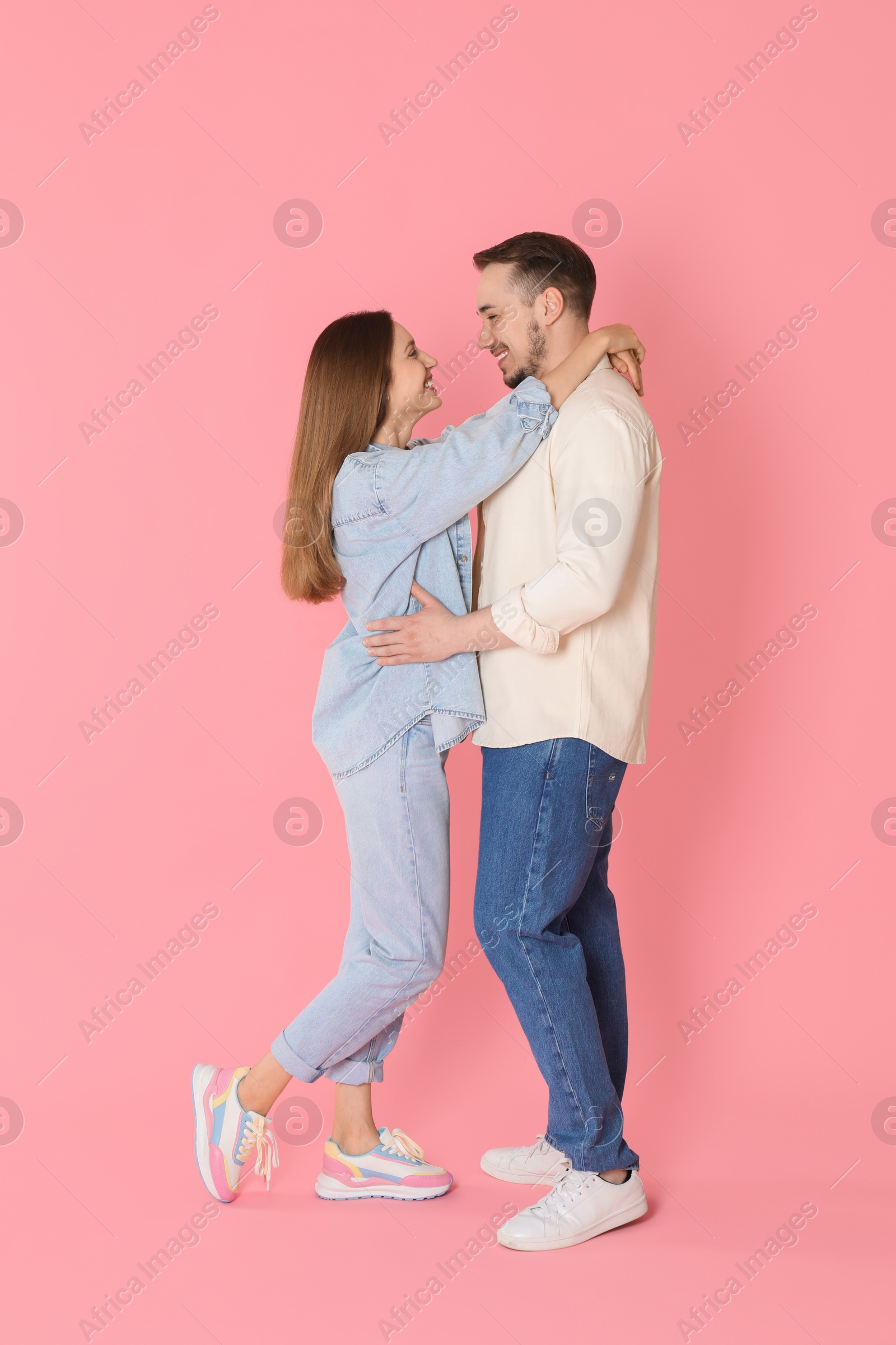 Photo of Happy couple hugging on pink background. Strong relationship