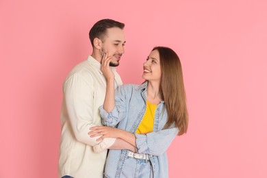 Photo of Happy couple enjoying each other on pink background