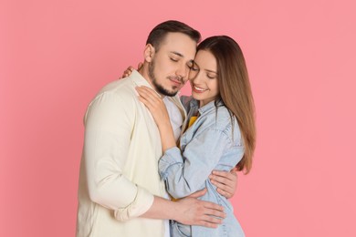 Photo of Happy couple hugging on pink background. Strong relationship