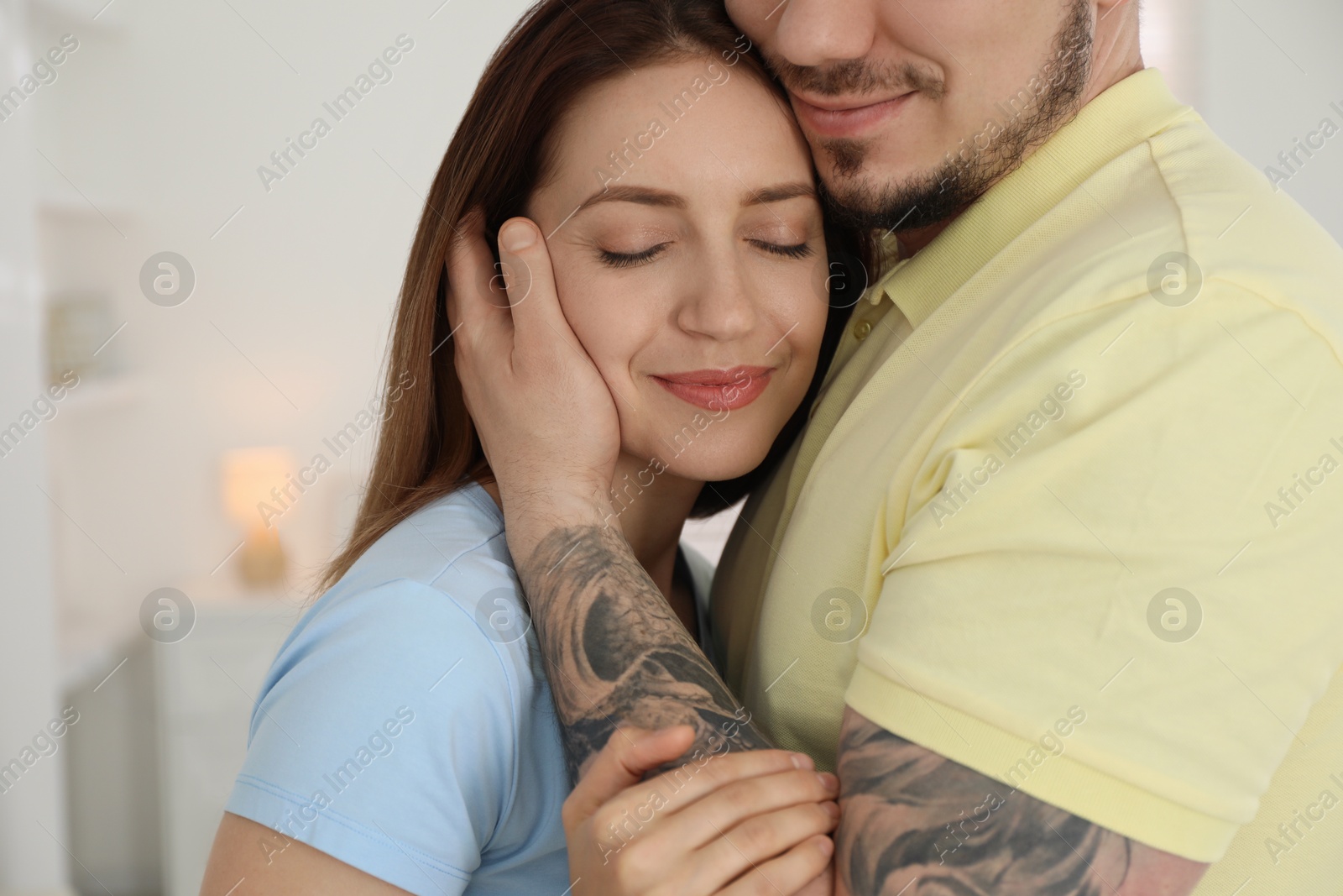 Photo of Man hugging his girlfriend at home, closeup