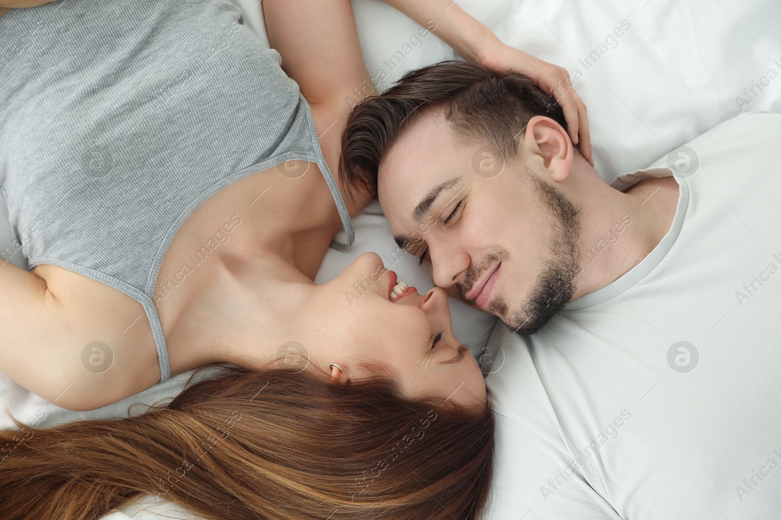 Photo of Family portrait of lovely couple on bed at home, top view