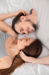 Photo of Family portrait of lovely couple on bed at home, top view