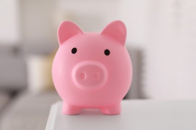 Financial savings. Pink piggy bank on white table