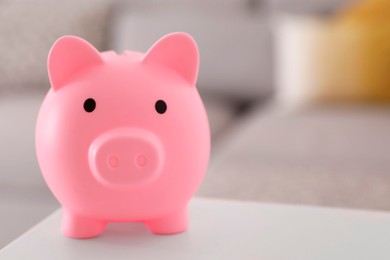 Financial savings. Pink piggy bank on white table