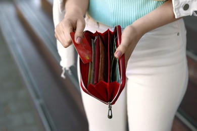 Woman holding purse with credit card outdoors, closeup. Space for text