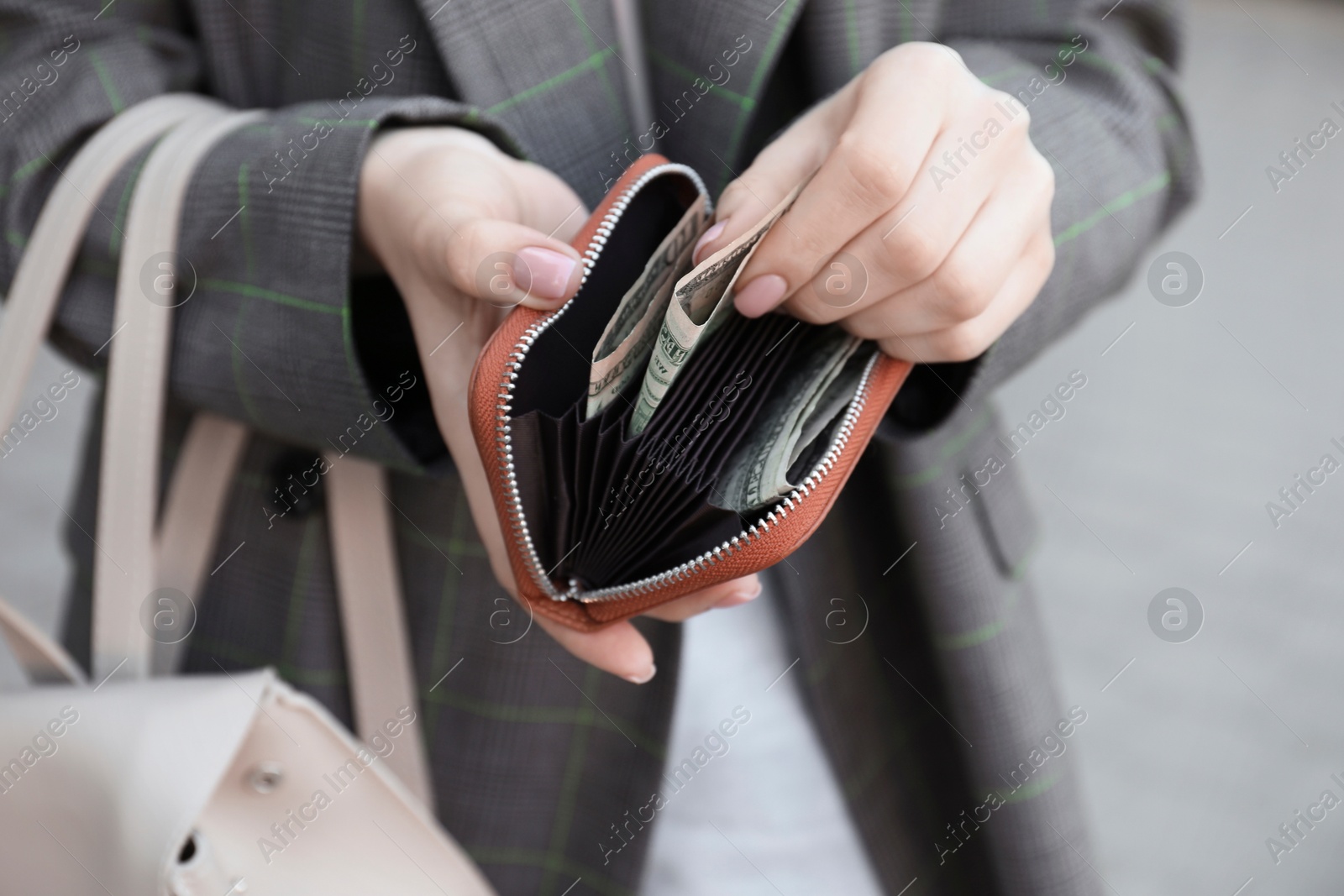 Photo of Woman holding purse with banknotes outdoors, closeup