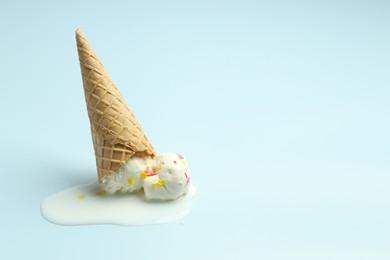 Photo of Melted ice cream in wafer cone on light background. Space for text