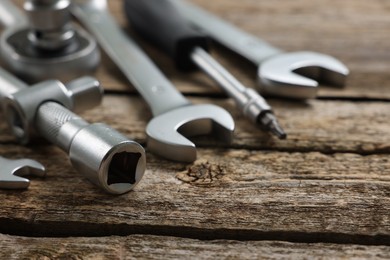 Different auto mechanic's tools on wooden table, closeup