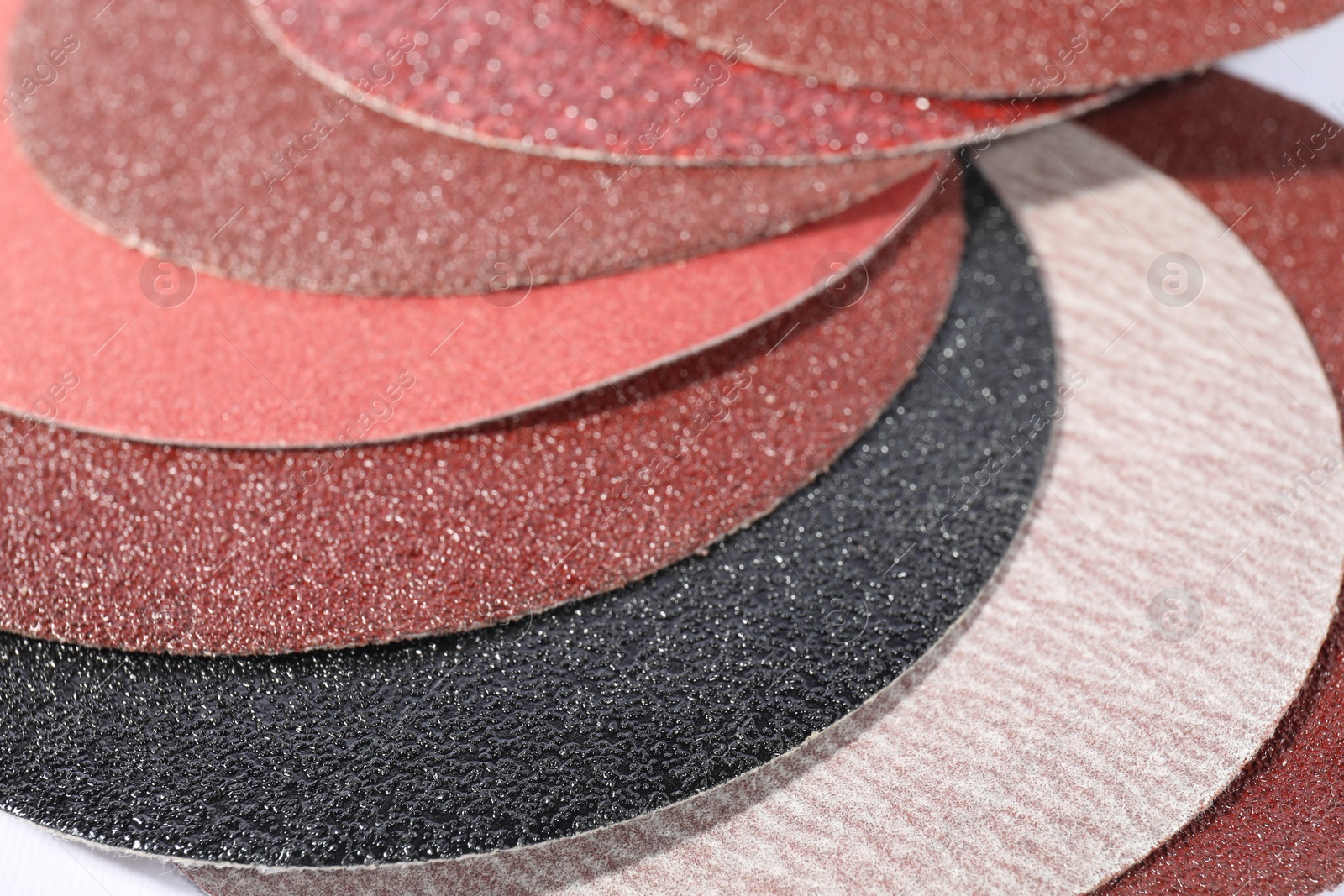 Photo of Many sheets of sandpaper as background, closeup