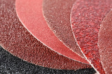 Photo of Many sheets of sandpaper as background, closeup