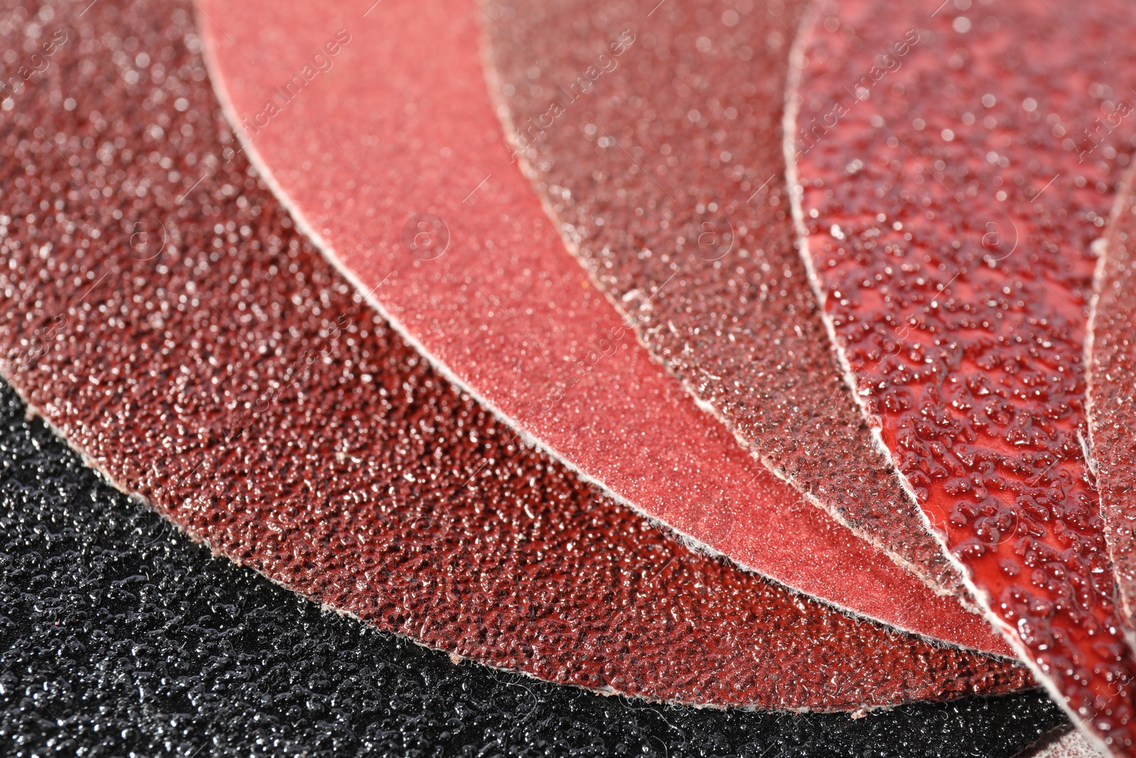 Photo of Many sheets of sandpaper as background, closeup