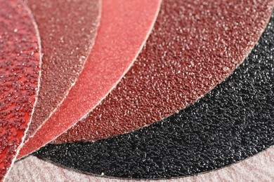 Photo of Many sheets of sandpaper as background, closeup