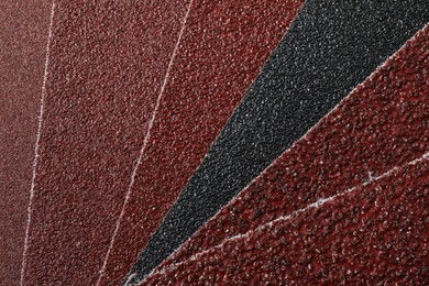 Photo of Many sheets of sandpaper as background, top view