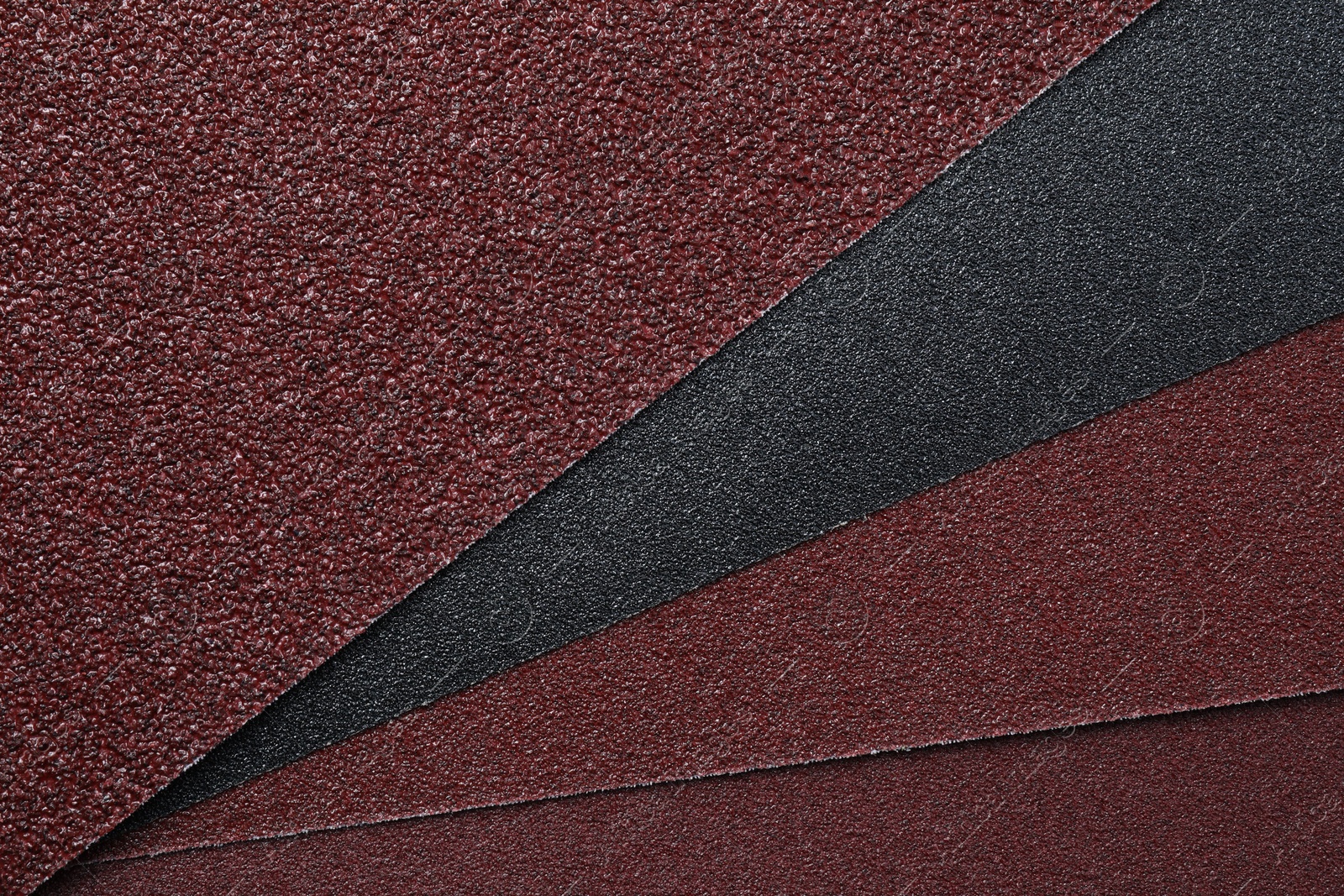 Photo of Many sheets of sandpaper as background, top view