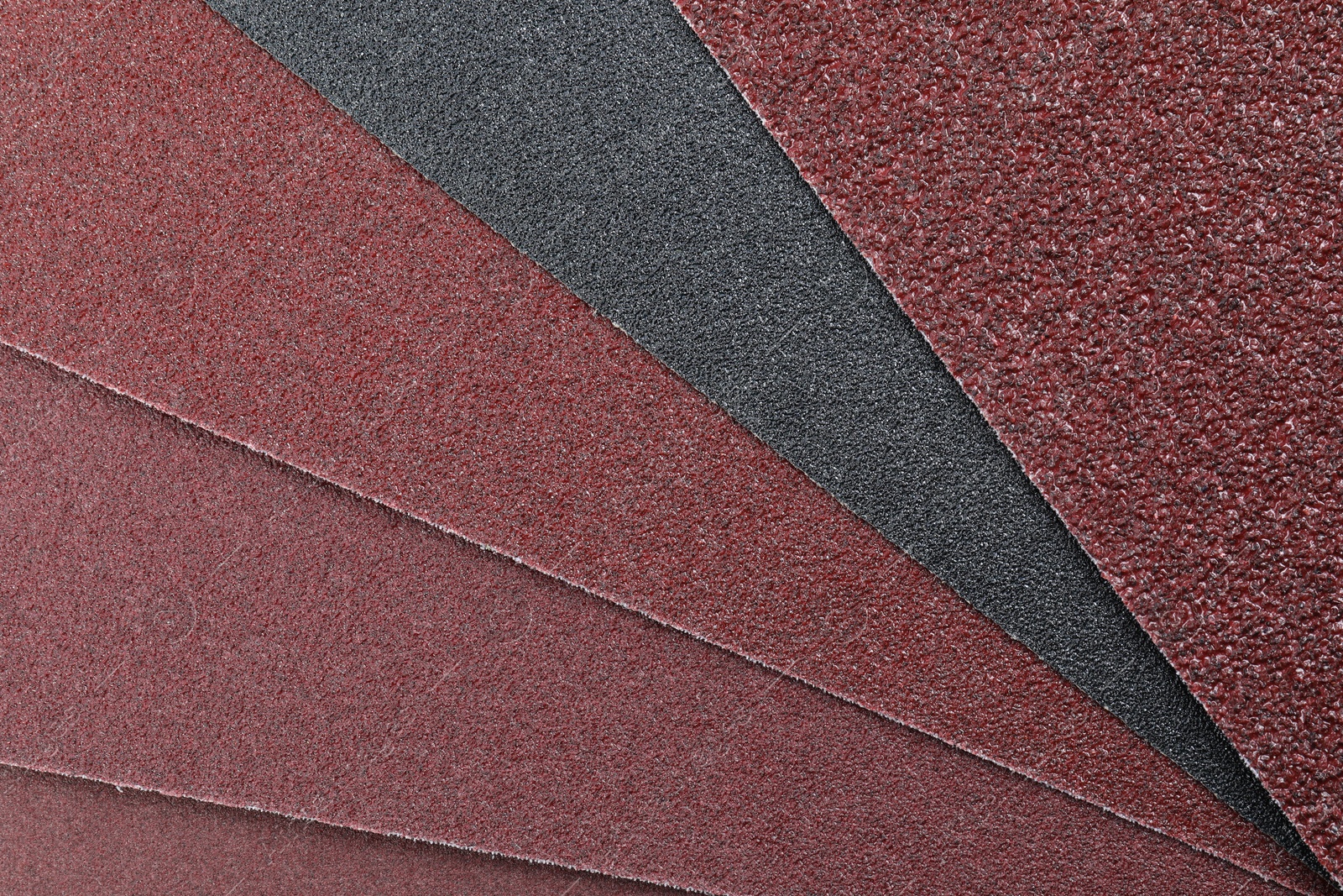 Photo of Many sheets of sandpaper as background, top view